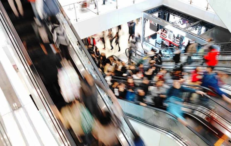 Belebte Rolltreppe in einem Einkaufszentrum: Strategisches Duftmarketing in hochfrequentierten Bereichen steigert die Verweildauer und den Erfolg im Einzelhandel.